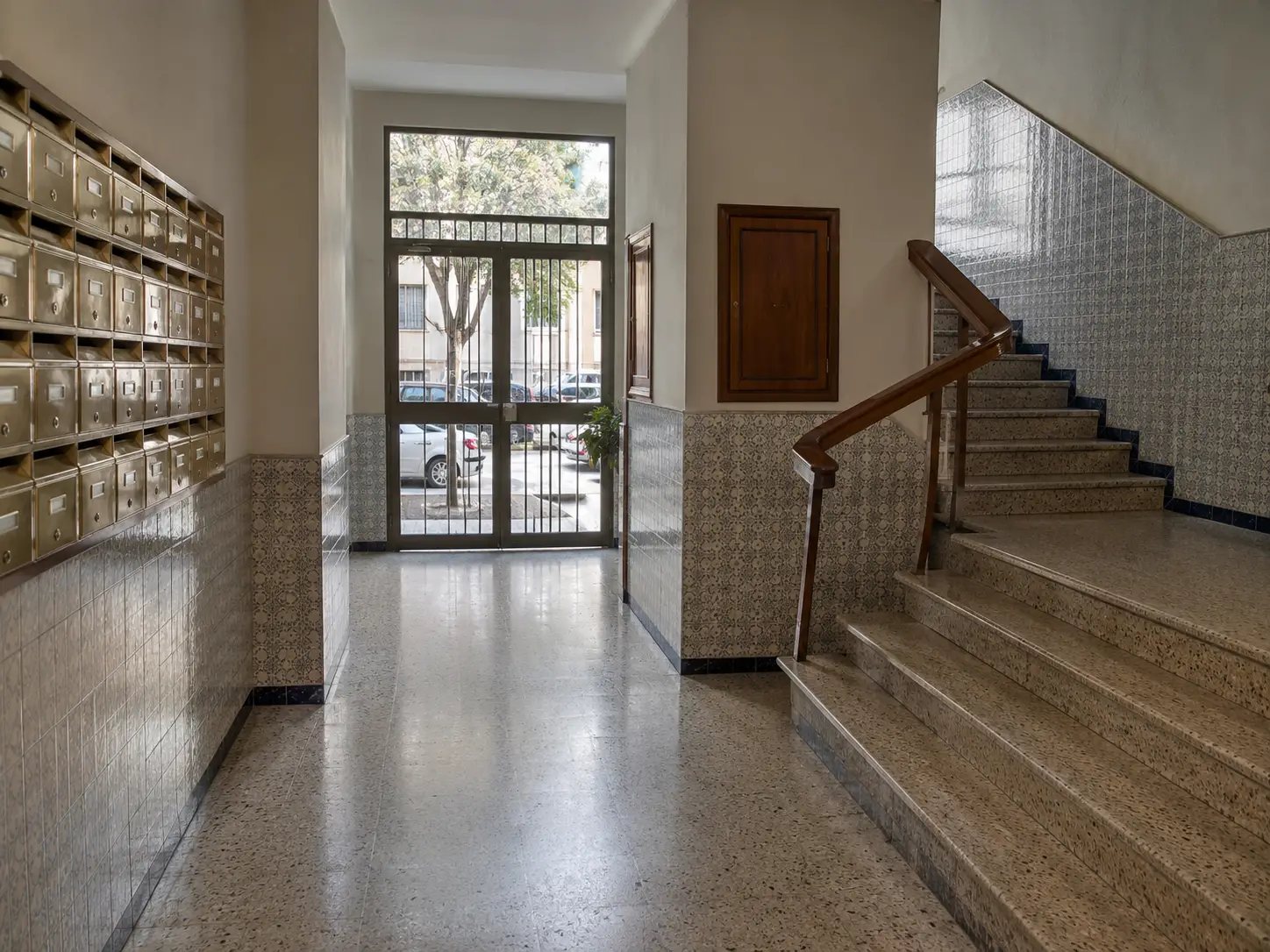 Portal y escalera de una comunidad de vecinos con el suelo fregado