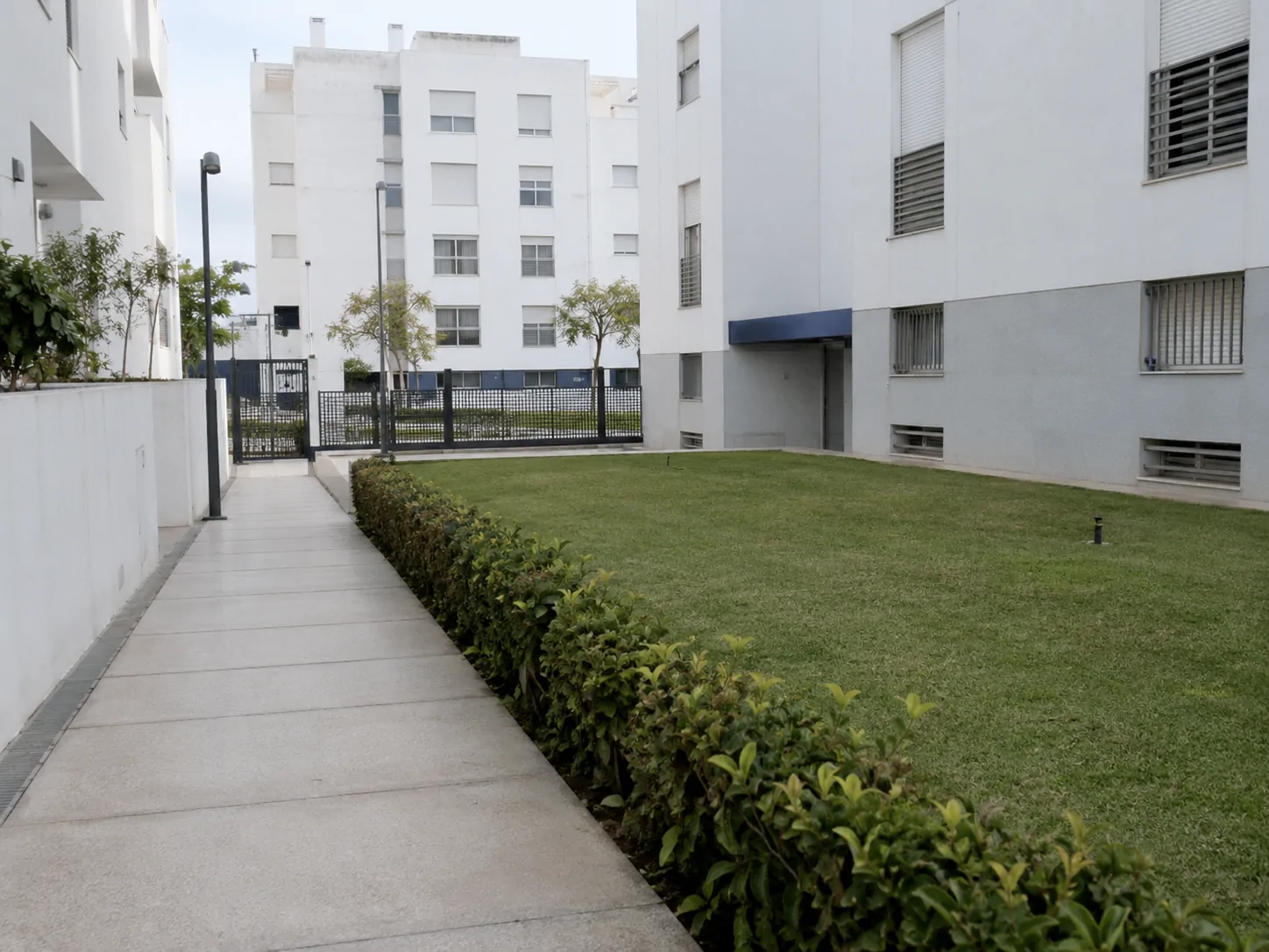Zona verde interior de una comunidad con el césped recién cortado